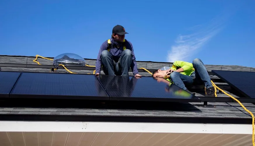 Монтажна бригада встановлює сонячні панелі на даху — партнери SolarProm